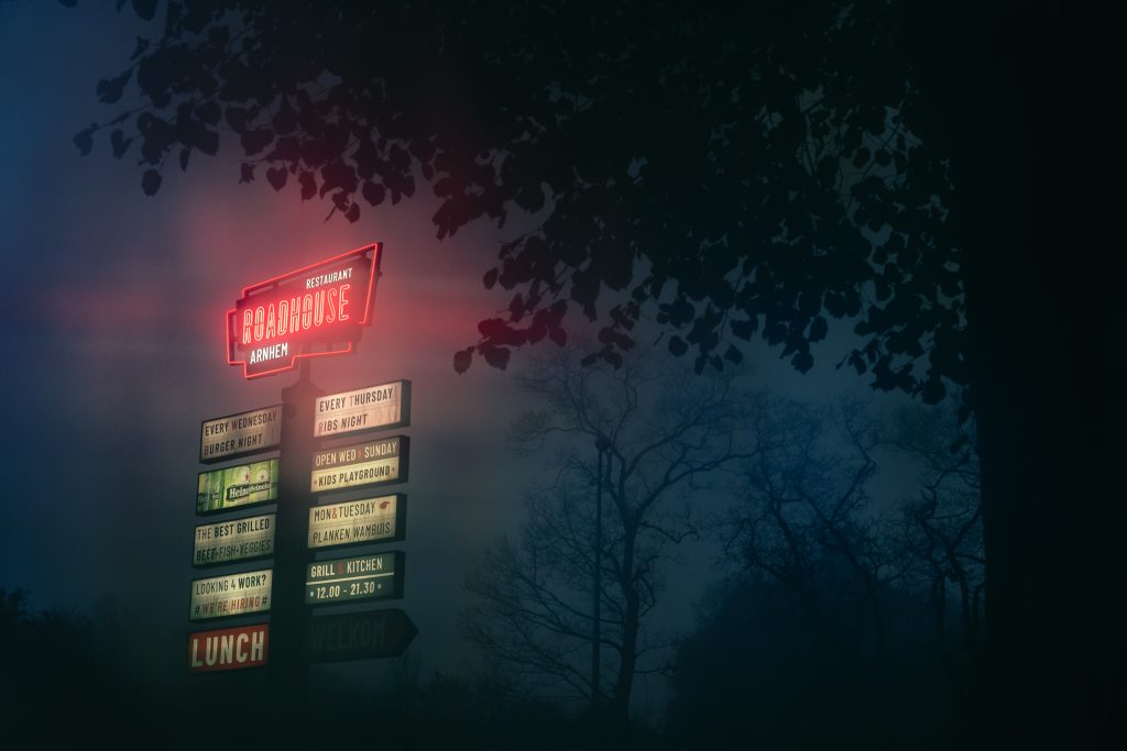 Rural area roadhouse sign in foggy fog conditions during autumn fall.