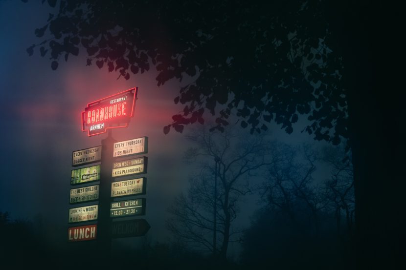 Rural area roadhouse sign in foggy fog conditions during autumn fall.